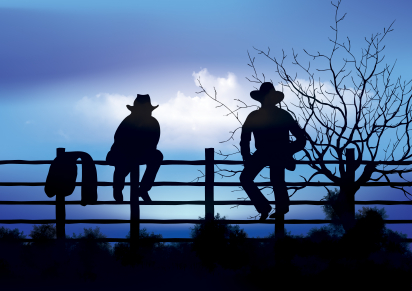 Two cowboys sitting on fence